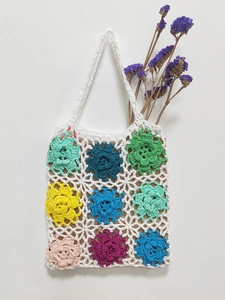 Detailed close-up of handmade crochet tote bag featuring multi-color floral granny squares