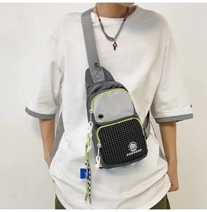 Detail of gray waterproof chest bag with neon yellow zippers and mesh pocket