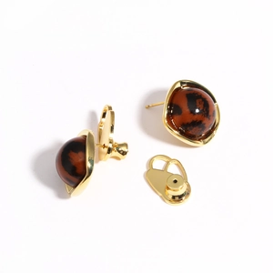 Detail of tortoise shell earring stud with golden base and secure backing support