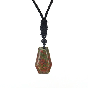 Detailed shot of unakite stone pendant with red and green pattern on black woven cord