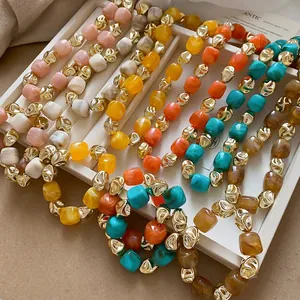 Chic irregular acrylic beaded bracelets with gold accents on a jewelry display tray