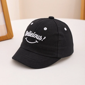 Close-up of 'Delicious!' smile embroidery on black cotton baby baseball cap fabric