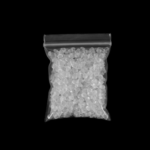 Macro shot of clear silicone earring backs in bulk bag on solid black background