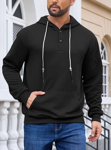 Detailed view of black men's hoodie featuring waffle texture fabric and button neckline