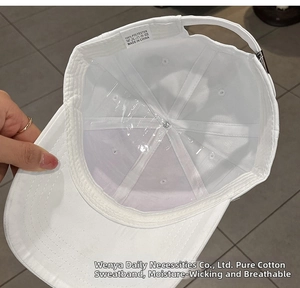Detail of white baseball cap interior featuring cotton sweatband and adjustable buckle