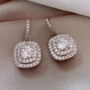 Square silver stud earrings with sparkling pavé micro-set cubic zirconia on champagne silk