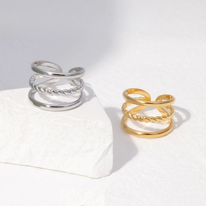 Macro detail of multi-layer gold and silver rings with twisted rope texture and open design