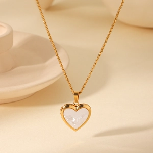 Détail macro du collier médaillon coeur plaqué or 18 carats avec nacre blanche incrustée