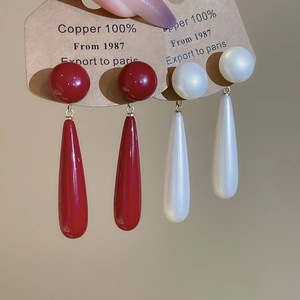 Detail of 18k gold plated drop earrings with pearl white and vintage red teardrop charms