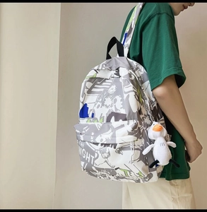 Detail of multi-color graffiti backpack with plush duck charm and high-density canvas texture
