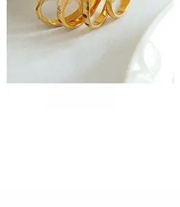 Close-up of four minimalist gold plated rings with colorful zircon inlay on white tray