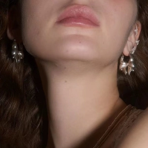 Silver bow-shaped earrings for women shown on model for a trendy and minimalist look