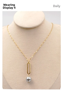Detail view of gold wave chain necklace with grey pearl pendant on elegant display stand