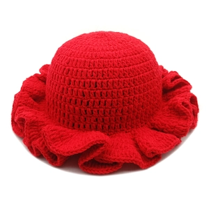 Detailed view of the handcrafted red crochet knit hat with ruffled wavy brim texture