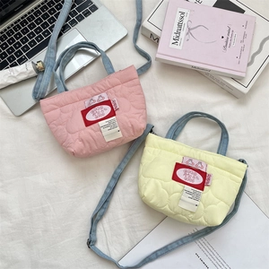 Détail de mini sacs cabas matelassés rose et jaune avec anses denim et écusson cerise