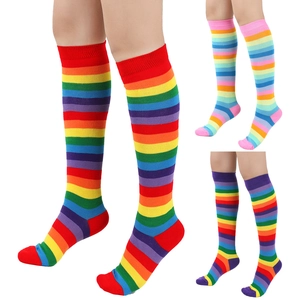 Three pairs of colorful rainbow striped knee high cotton socks for women on white background