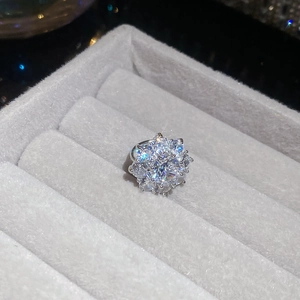 Macro shot of sparkling zircon flower ear clip on grey velvet jewelry display box