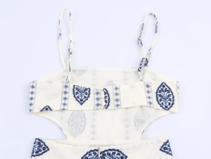 Detail of blue floral embroidery on white cotton midi dress with adjustable straps