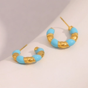 Detail of 18K gold plated C-shaped earrings with blue enamel and twisted rope texture