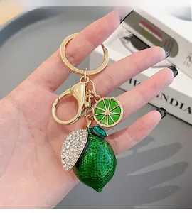 Detail of green lemon keychain with white rhinestones and gold lobster clasp decoration