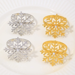 Close-up of gold and silver snowflake napkin rings with rhinestones on a ceramic plate
