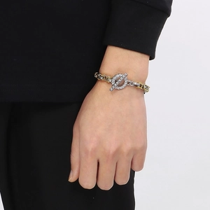 Detail of two-tone stainless steel king chain with skull OT clasp on a model's wrist