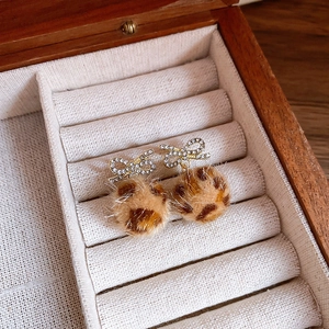 Macro shot of leopard print earrings with sparkling rhinestone bowknot detail