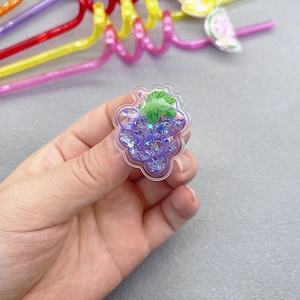 Detail of purple grape ornament with glitter sequins and green leaves on plastic straw