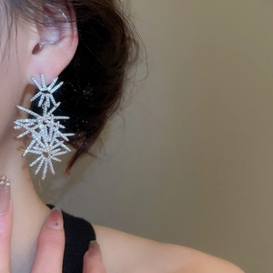 Macro shot of silver fireworks drop earrings with sparkling cubic zirconia clusters