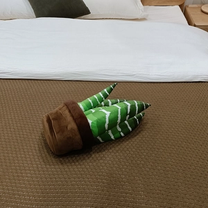 Vue détaillée d'une plante en peluche dans un pot marron sur une couverture douce