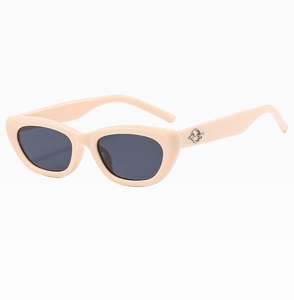 Detail view of pink cat eye sunglasses with grey lenses and silver metal hinge decoration