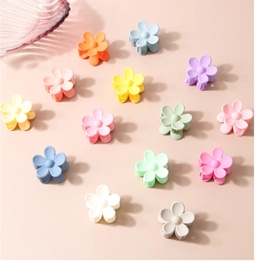 Detailed macro view of mini flower hair claws in colorful matte macaron shades