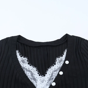 Dettaglio del top in maglia con scollo a V, bordo in pizzo bianco e bottoni rotondi