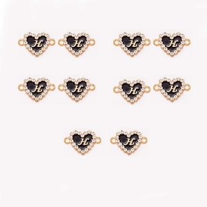 Close-up of 10 heart-shaped black enamel charms with golden letter H and crystal rhinestones