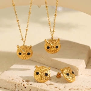 Golden owl jewelry set with black stone eyes featuring two necklaces and stud earrings