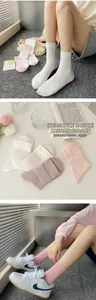 Détail de chaussettes en coton doux en blanc pastel, beige, rose et gris violet
