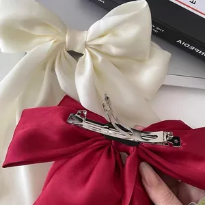 Dual-layered satin bow hair clips in cream white and wine red with spring metal fasteners