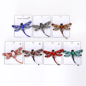 Detail of seven dragonfly brooches set with multi-colored crystals on display cards