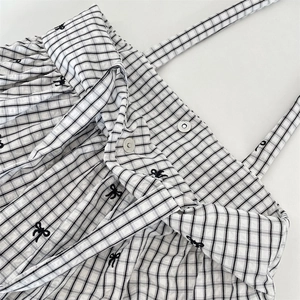 Close-up of black and white checkered tote bag with bow embroidery and magnetic snaps