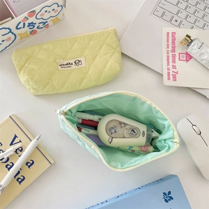 Macro detail of quilted macaron stationery bags with soft texture and brand label