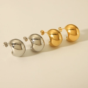 Detail of high-polished gold and silver C-shaped hollow hoop earrings in a diagonal layout