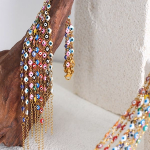 Colorful Evil Eye bracelets in gold-plated stainless steel hanging on a branch