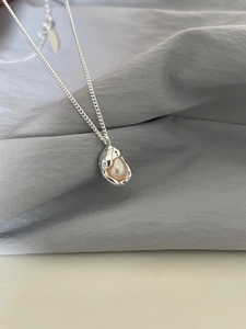 Close-up of S925 sterling silver necklace with irregular metal wrapped freshwater pearl