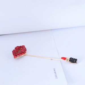 Detail showing lip and lipstick brooch with red rhinestones and gold-tone long pin