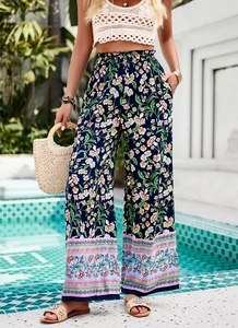 Détail du pantalon large à fleurs à taille haute froncée et imprimé sur l'ourlet