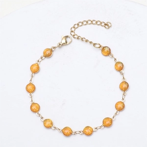 Detail of 18K gold-plated bracelet featuring thirteen orange glitter resin beads