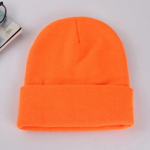 Close-up of bright orange ribbed knit beanie showing soft texture and premium quality
