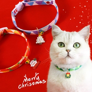 Detail of Christmas plaid pet collars with festive charms and bells on a white cat
