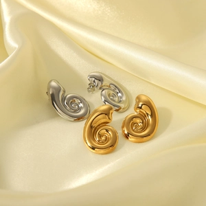Détail macro de boucles d'oreilles spirales polies en finitions dorée et argentée