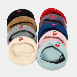 Detail view of nine different colored berets with embroidered red cherry patterns